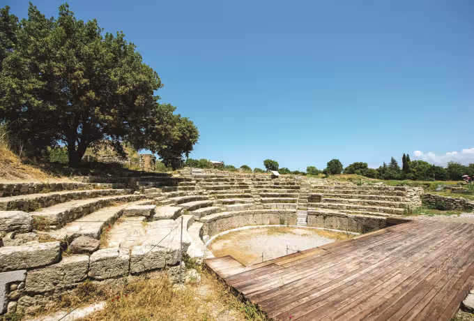 Curved stone rows still standing at the small theatre of Troy, planks laid across the floor