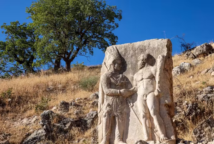 Eroded carving at Arsameia in Adiyaman where two upright forms grasp one another's hand