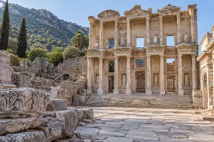 Celsus Library at Ephesus above a sunlit marble forecourt with carved stone fragments