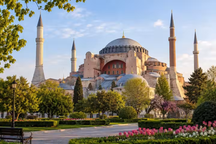 Hagia Sophia and its four minarets above Sultanahmet park in warm morning light