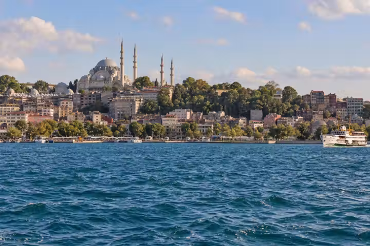 Istanbul skyline and a white passenger ferry across the Golden Horn in afternoon light