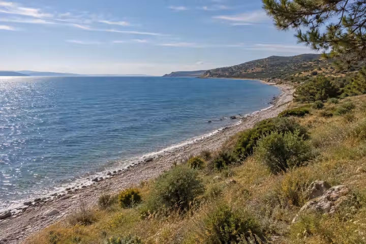 Quiet pebble shoreline and scrub-covered hills on the Gallipoli coast