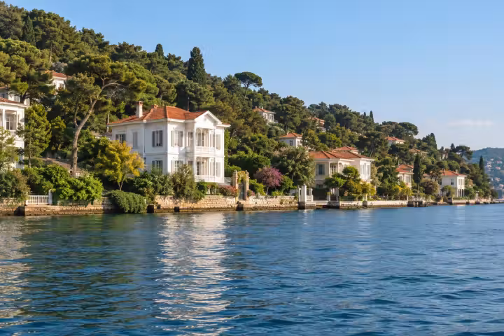 White timber houses and wooded slopes beside the blue Marmara water on Buyukada